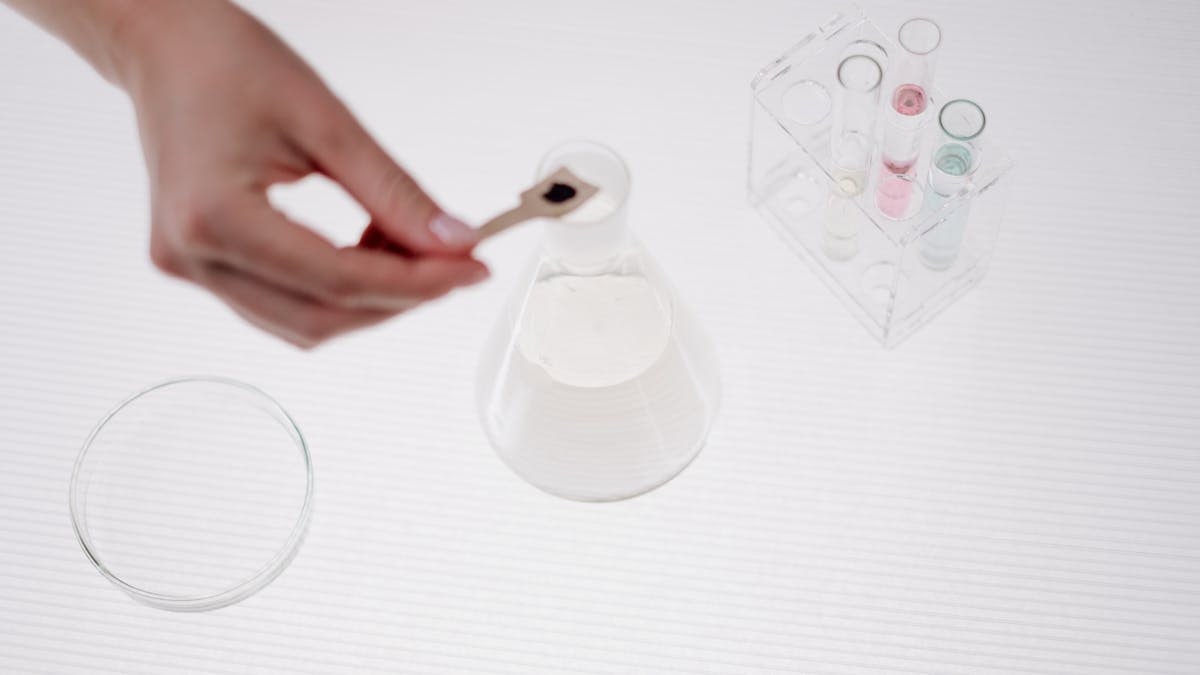 Close-up of a person handling a beaker in a science lab setting.
